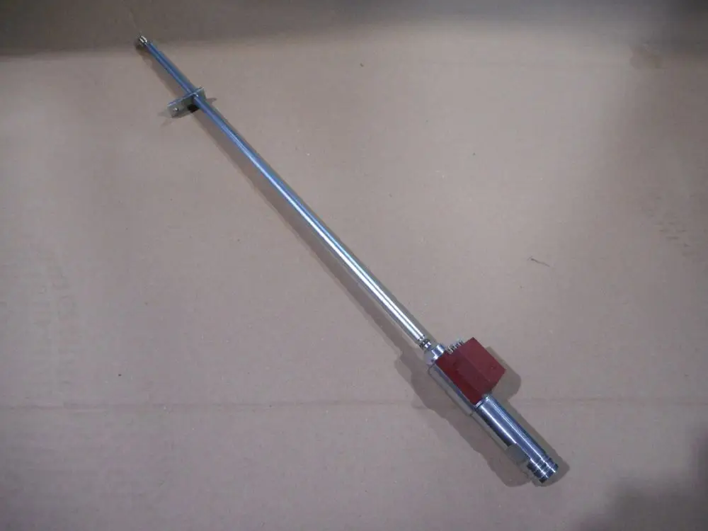 Remeha Düsenschaft mit langem Metallrohr und rotem Anschlussstück, auf flacher Unterlage abgebildet.